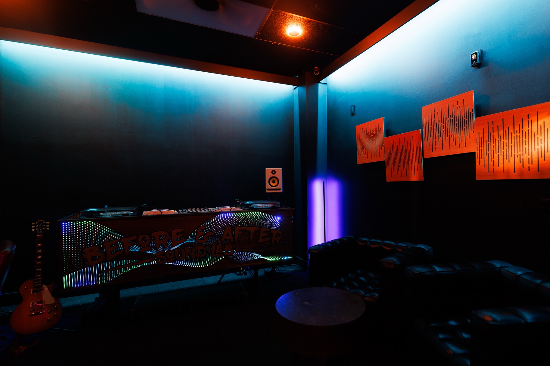 The DJ booth, its lit front panel below the acoustic panels